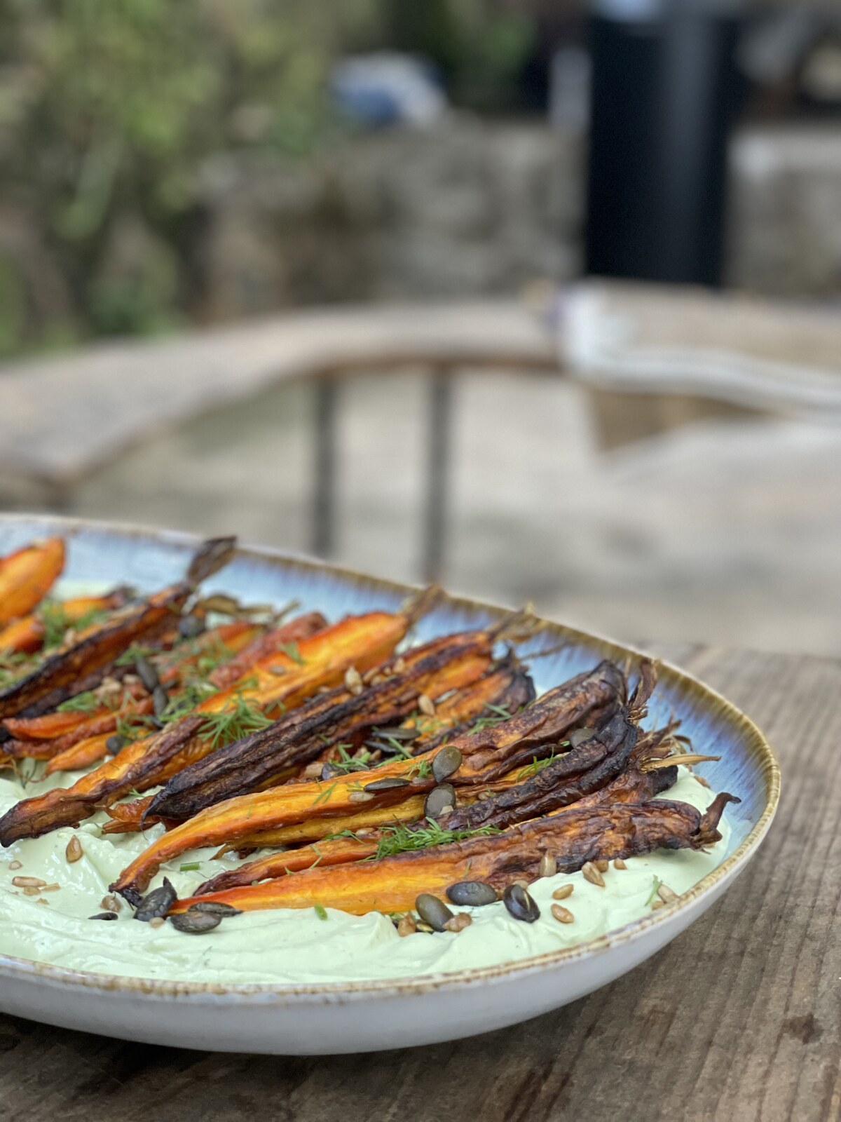 Roasted carrots on green plant-based cream with seeds and herbs by Skarabo Life