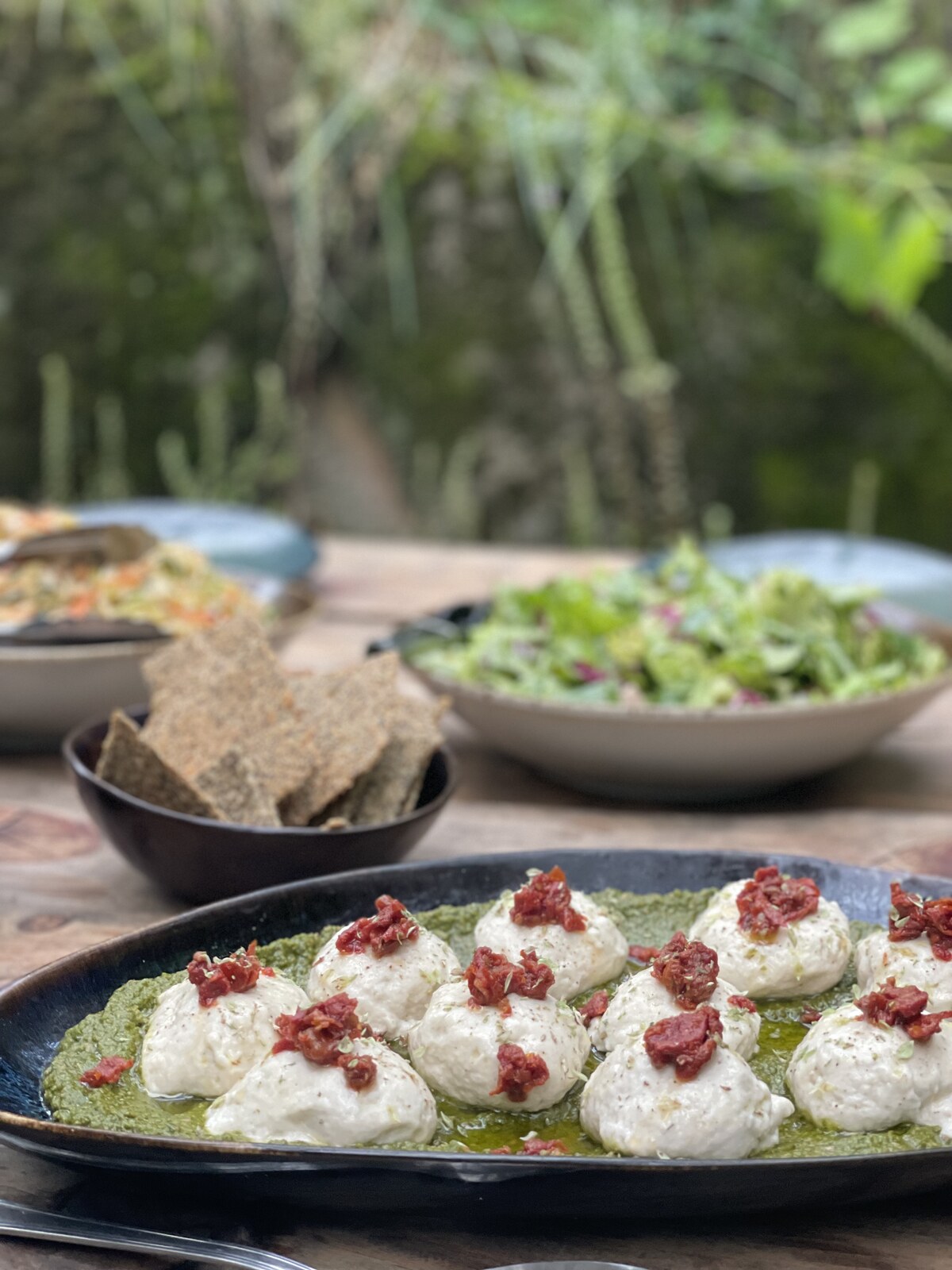 Plant-based dumplings on green sauce with crisp toppings by Skarabo Life